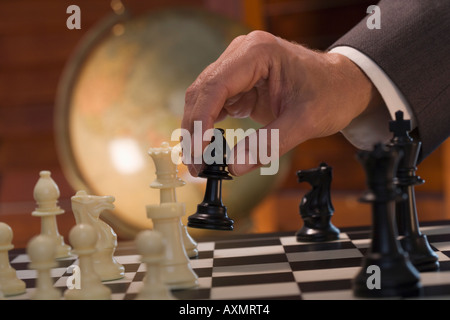 Businessman moving chess piece Stock Photo