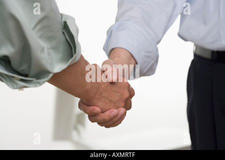 Men in shirtsleeves shaking hands Stock Photo