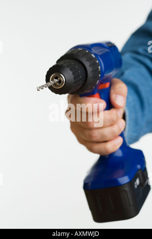 Close up studio shot of man holding cordless drill Stock Photo
