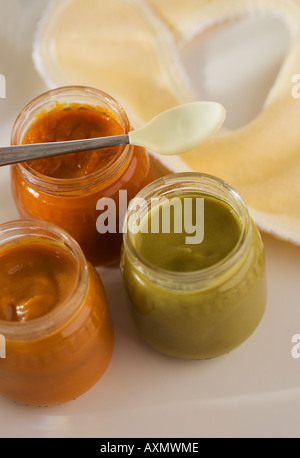 Close up of baby food in jars with spoon and bib Stock Photo