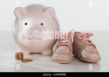 Studio shot of baby shoes and piggy bank Stock Photo