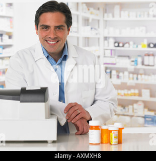 Male pharmacist at counter with medication Stock Photo