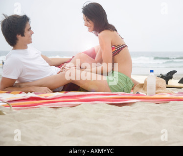 Couple sitting on blanket at beach Stock Photo