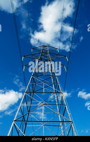 Electricity Suspension Tower, or pylon, set against a blue sky with puffy white clouds Stock Photo