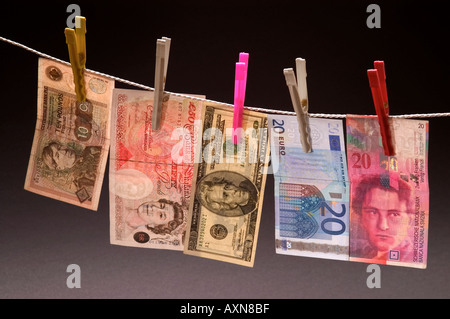 Washed money hanged on a rope currency pegs dollars pounds euros leva note dirty money drying Stock Photo