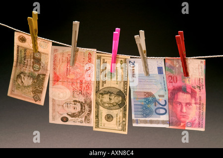 Washed money hanged on a rope currency pegs dollar pound euro note dirty money drying Stock Photo