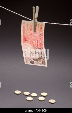 Washed money hanged on a rope currency pegs 5 pounds note dirty money drying coins Stock Photo