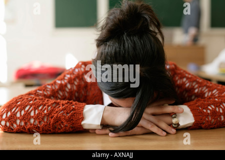 Teenage girl sleeping in a classroom Stock Photo