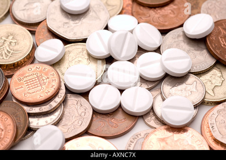 Medicine costs pharmaceutical industry making money pills and coins UK pounds and pence Stock Photo