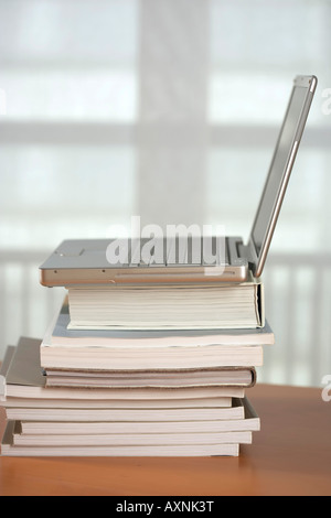 Laptop on a stack of books Stock Photo