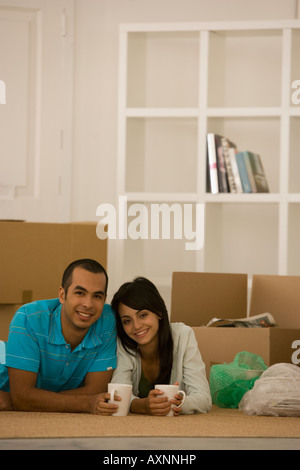 Young couple next to unpacked moving boxes Stock Photo