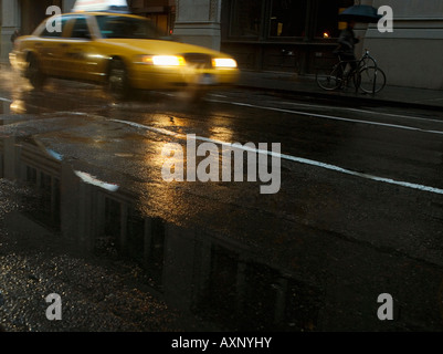 A taxi driving in the rain on a New York street. Stock Photo