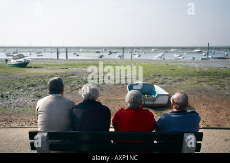 VISITORS TO WEST MERSEA SIT AND ADMIRE THE SEA VIEW Stock Photo