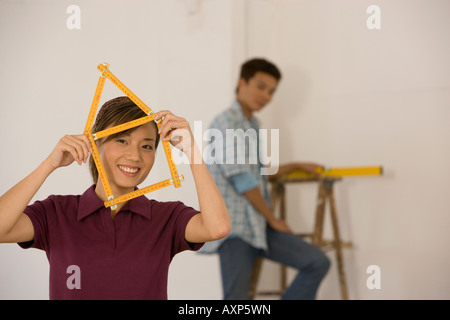 Asian woman with folding ruler shaped like house Stock Photo