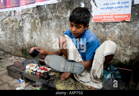 Young boy working as a shoe shine in Dhaka, Bangladesh Stock Photo