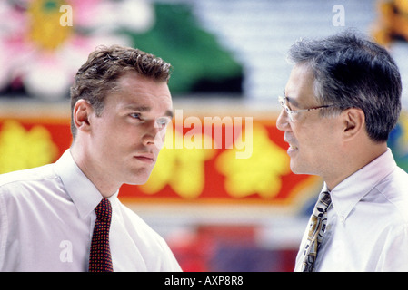 Asian and western businessmen talking outdoors and discussing buisness Stock Photo