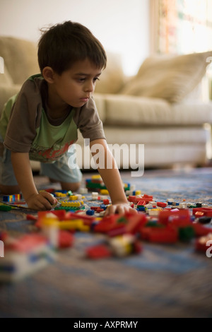 Boy aged six years plays with Lego building blocks Stock Photo