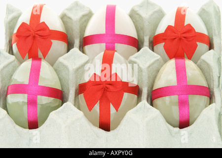Decorated semi precious stones in the shape of Easter eggs in paper carton Stock Photo