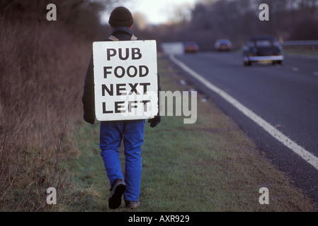 Man advertises village pub food at the side of the road England HOMER SYKES Stock Photo