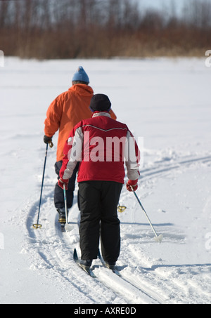 Elderly couple cross-country skiing on sea ice , Finland Stock Photo
