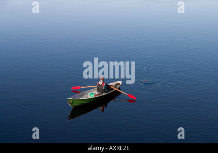 Fisherman rowing and trolling from a rowboat / skiff at river Oulujoki ,  Finland Stock Photo