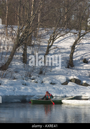 Fisherman on rowboat / skiff at Wintertime at River Oulujoki , Finland Stock Photo