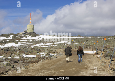 Walkers approaching transmitter station on summit of Tron mountain Tynset Hedmark Norway Stock Photo