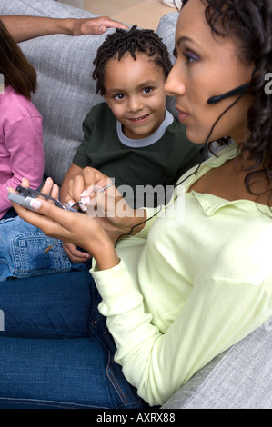 Portrait of boy looking at his mom who is ignoring him while on the phone. Stock Photo
