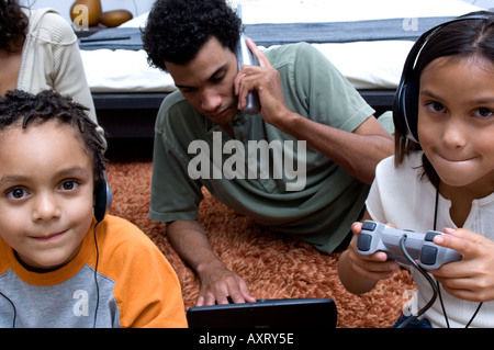 Portrait of two kids enjoying technology with their dad. Stock Photo