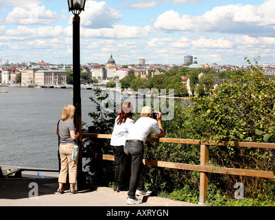 Three people gazing into the sea Stock Photo