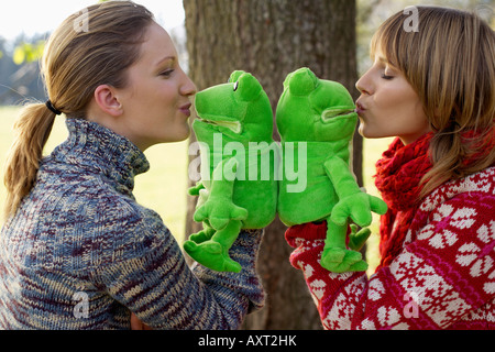 Two young women with frog hand puppets, selective focus Stock Photo