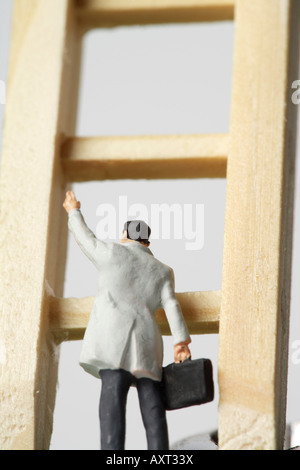 Businessman figurine on a ladder Stock Photo