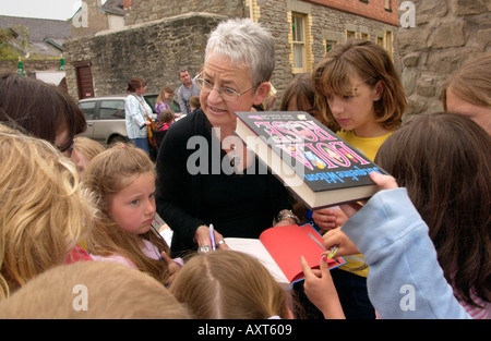 Childrens author Jacqueline Wilson surrounded by a group of children signing books in a street at Hay on Wye Powys Mid Wales UK Stock Photo