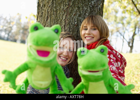 Two young women with frog hand puppets, selective focus Stock Photo