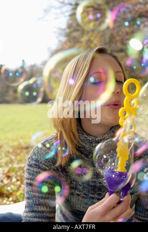 Young woman making soap bubbles, close-up Stock Photo
