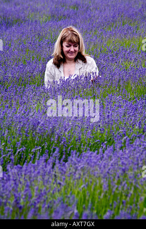 Girl lavender field in a blue dress with flowing hair in a hat stands ...