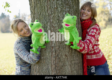 Two young women with frog hand puppets, selective focus Stock Photo