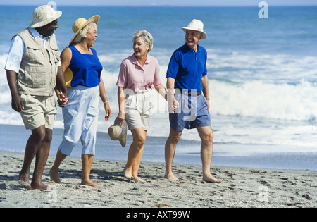 Seniors relaxing together, walking on beach, Miami Stock Photo