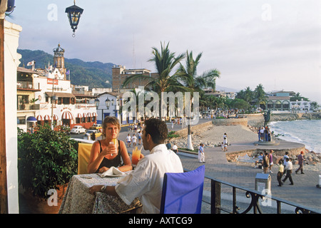Couple having sunset drinks at oceanfront restaurant in Puerto Vallarta Mexico Stock Photo