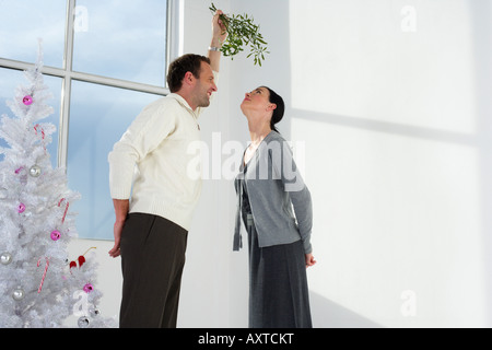Couple standing under a mistletoe Stock Photo
