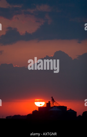 The sun sets behind a grain elevator in Central Illinois. Stock Photo
