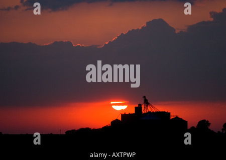 The sun sets behind a grain elevator in Central Illinois. Stock Photo