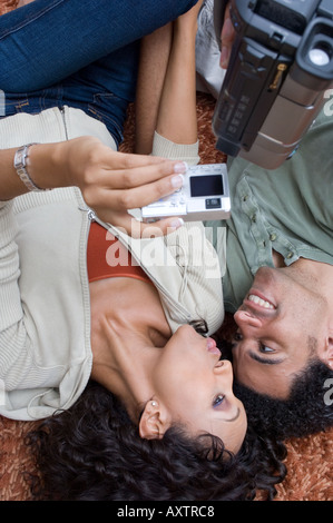 Portrait of a couple video recording while laying on the carpet. Stock Photo