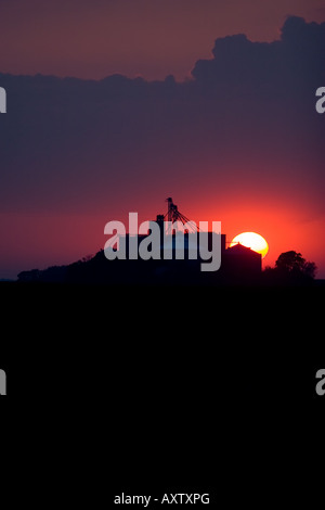 The sun sets behind a grain elevator in Central Illinois. Stock Photo