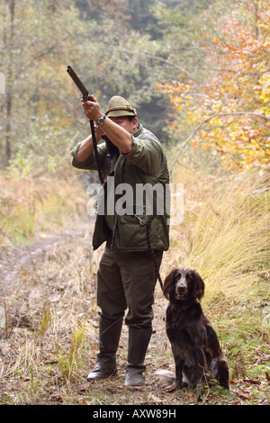 battue hunter in field landscape with hunting dog, Germany, North Rhine-Westphalia Stock Photo