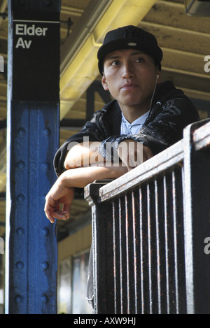 Young man waiting for subway and listening to music through his MP3-Player, USA, Bronx, New York Stock Photo