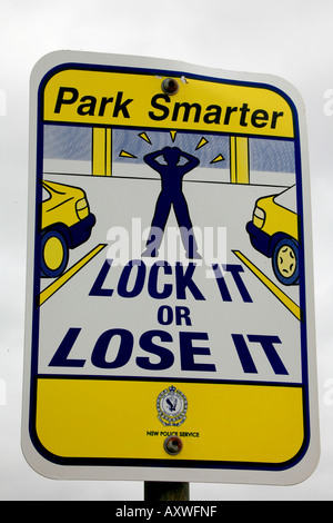 A sign warns drivers to lock their cars at an Australian beachside parking lot Stock Photo