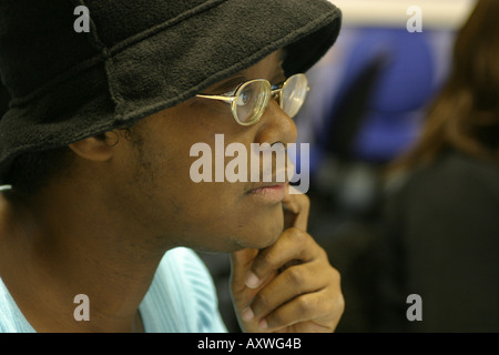 male student in class wearing hat and glasses looking studious Stock Photo