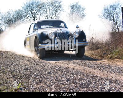 black Jaguar XK 150 FHC at speed on gravel road International Horneland Rally Netherlands Stock Photo