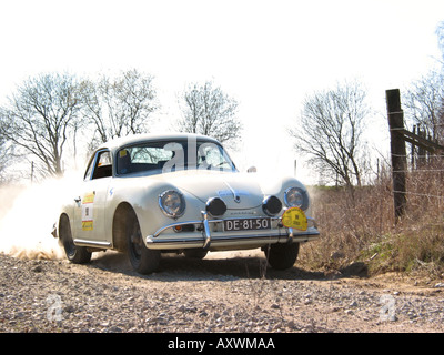 white rally Porsche 356 saloon at speed on gravel road International Horneland Rally Netherlands Stock Photo